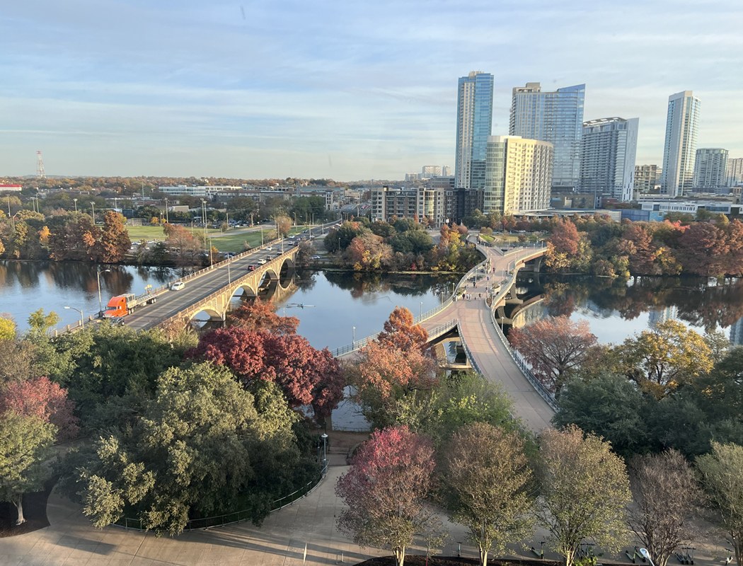 Aerial view of downtown Austin skyline with the Lamar pedestrian bridge over Lady Bird Lake
